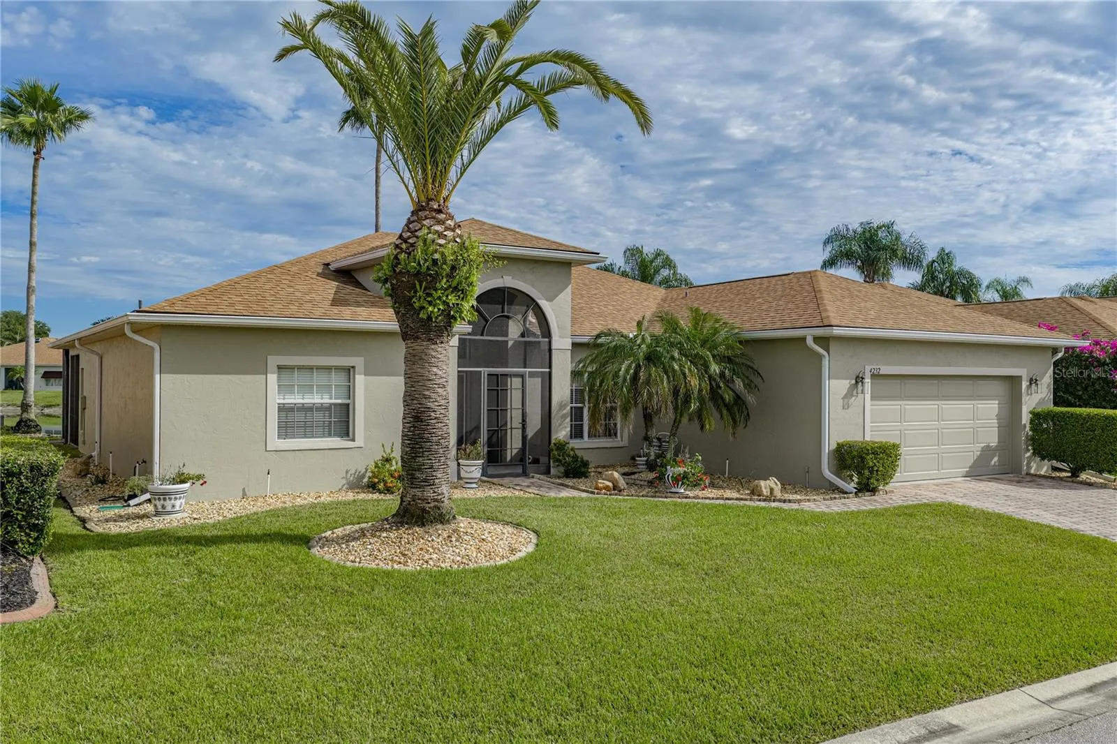 The quality landscaping encircles this home and includes stately palms and other plantings.