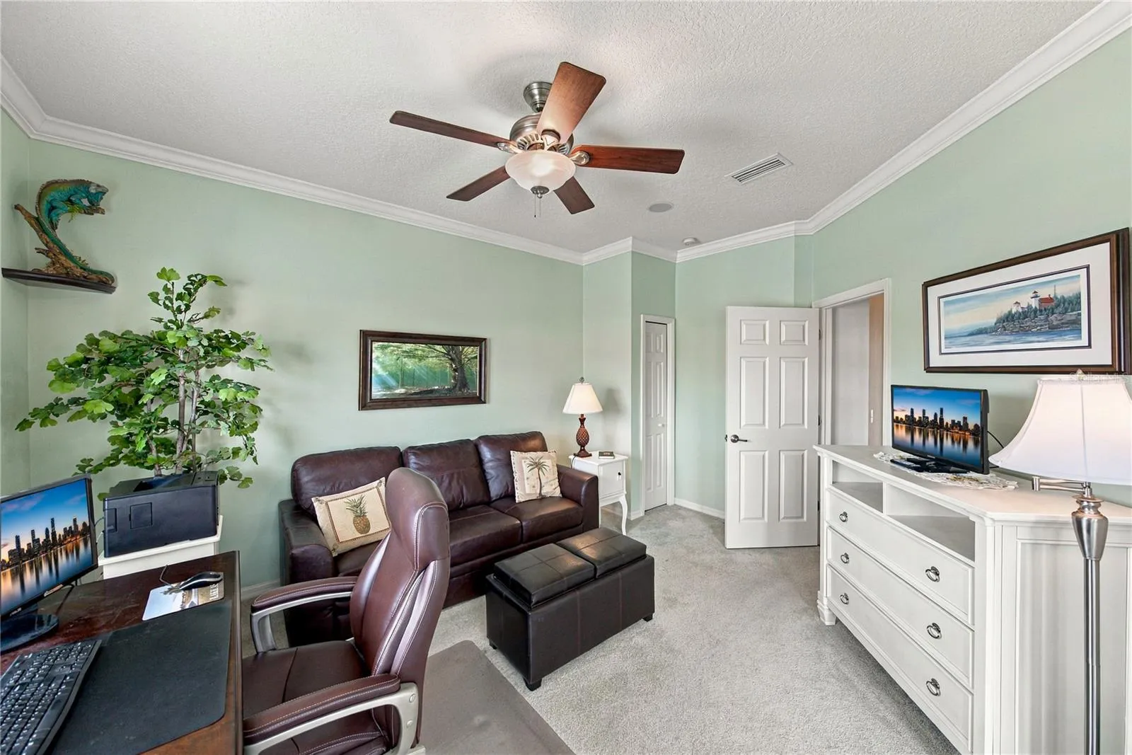 The third bedroom has a closet, crown molding, a custom ceiling fan with light, and is adjacent to the guest bath.