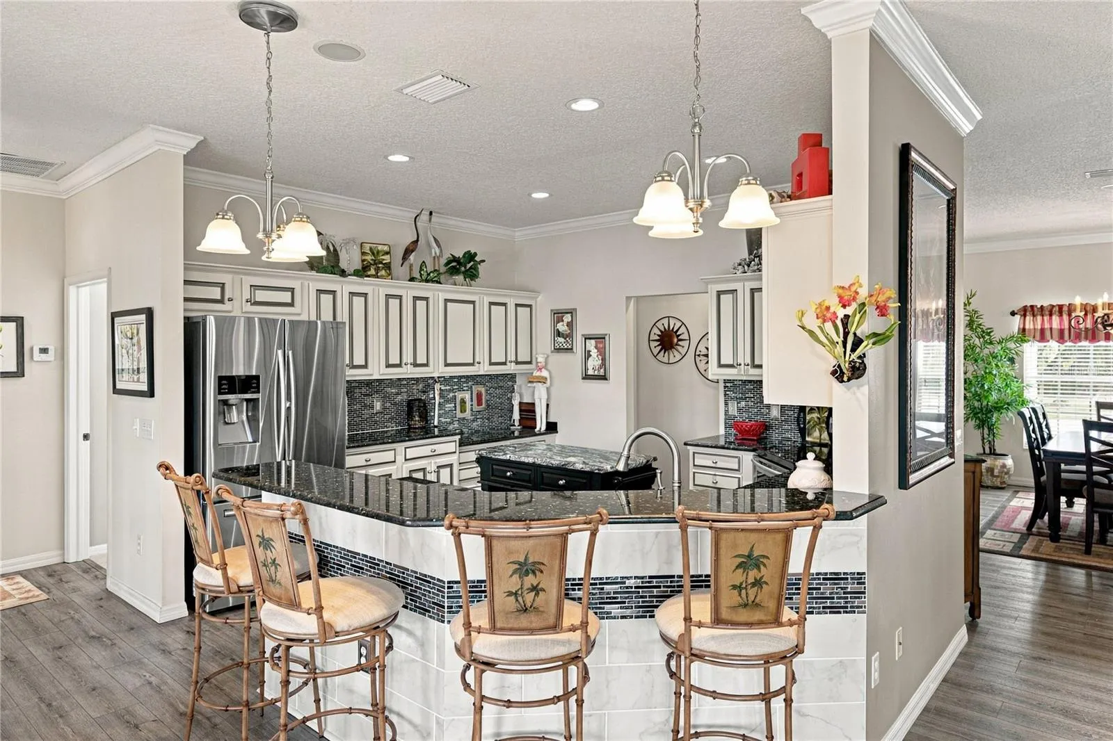 The snack bar has granite counter and pendant lights.