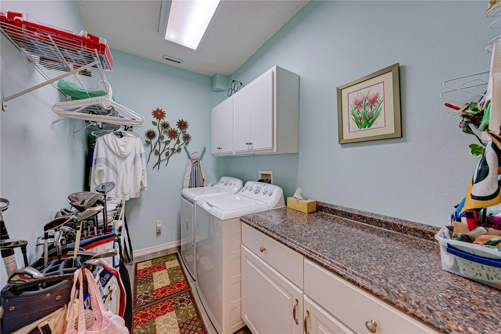 The inside laundry room is just off the kitchen and features additional storage and cabinetry. The new washer and dryer stay.