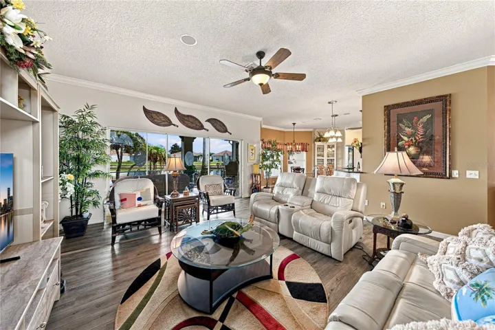 The triple slider at the north end of the living room opens to the expanded covered and "bird caged" lanai.