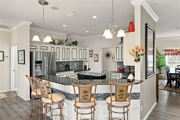 The snack bar has granite counter and pendant lights.