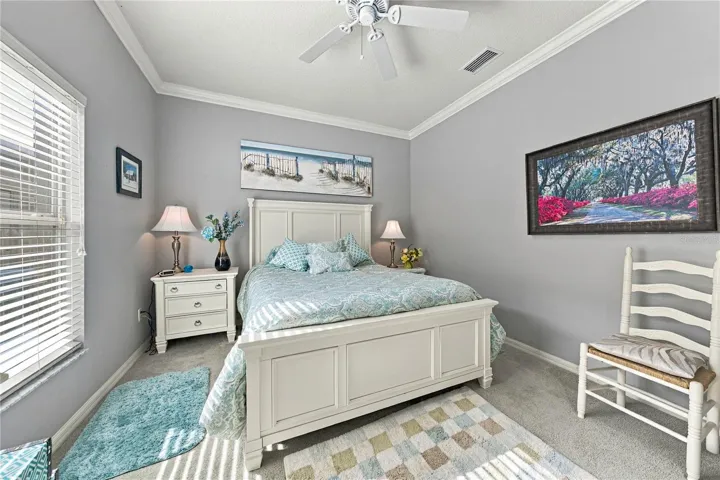 The second bedroom has crown molding and window treatments.