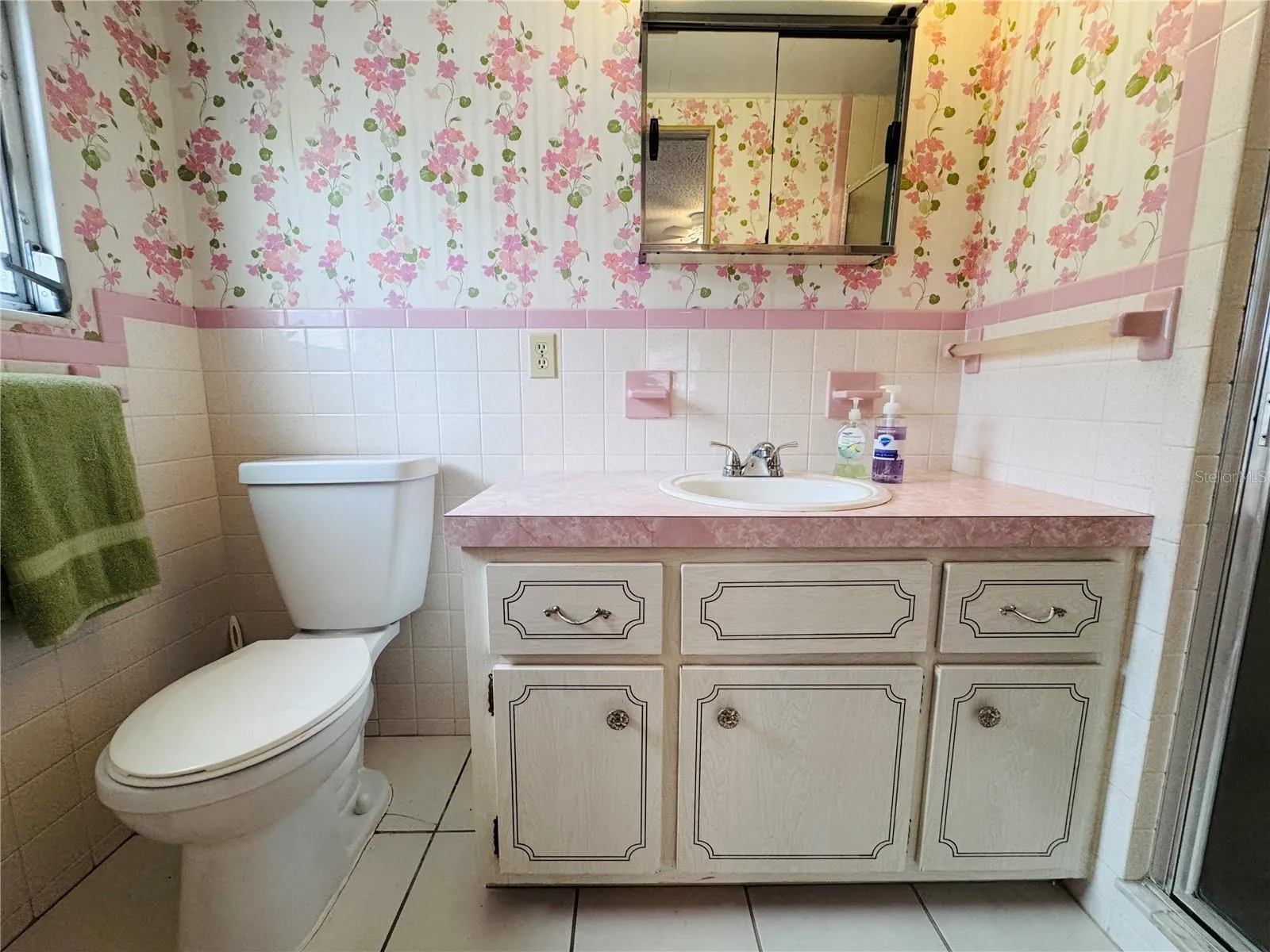 Primary Bathroom with single vanity and walk in tiled shower.