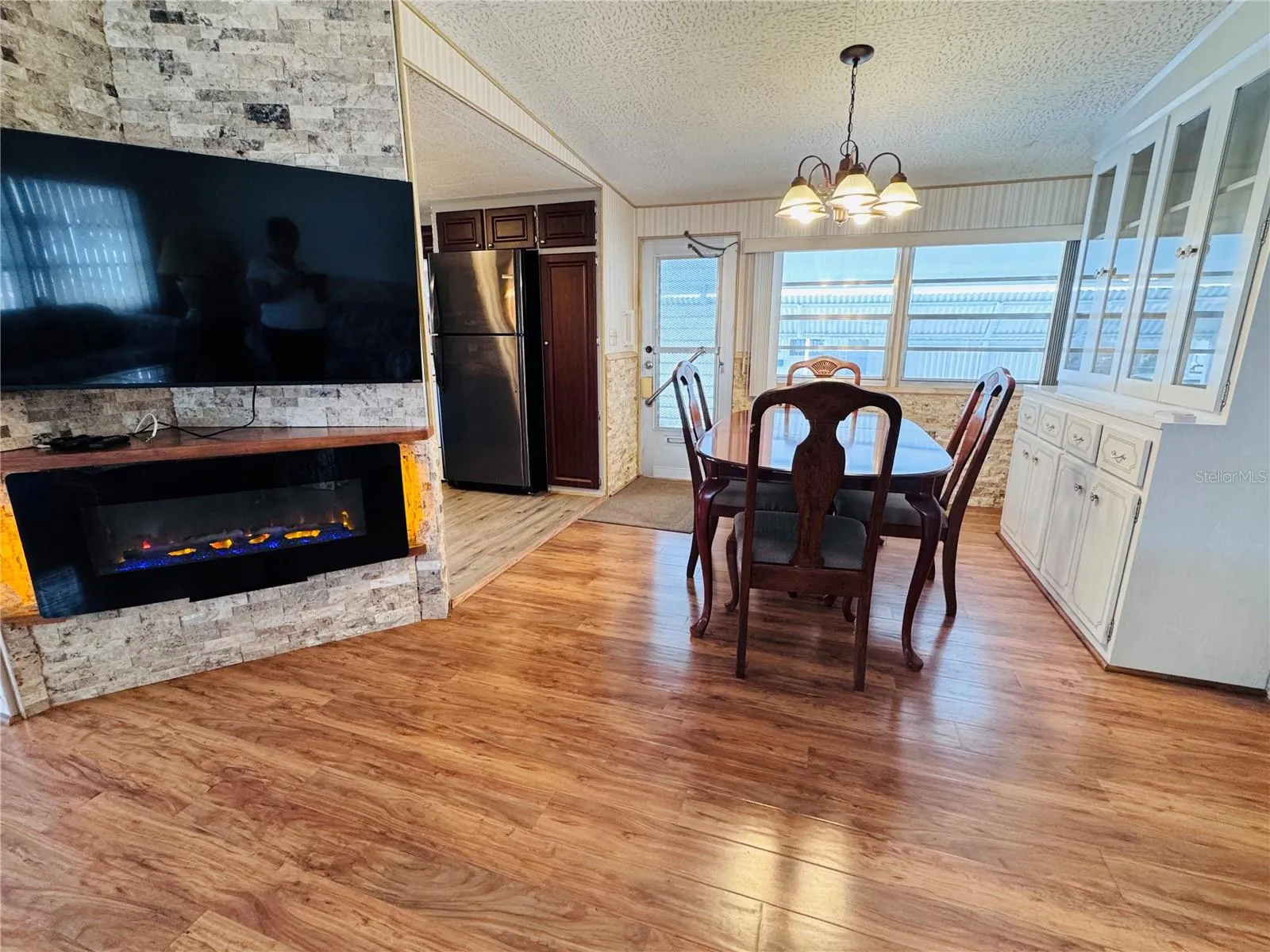 View of the dining room and built in 55 inch TV with electric fireplace.