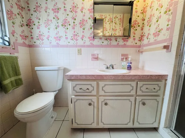 Primary Bathroom with single vanity and walk in tiled shower.