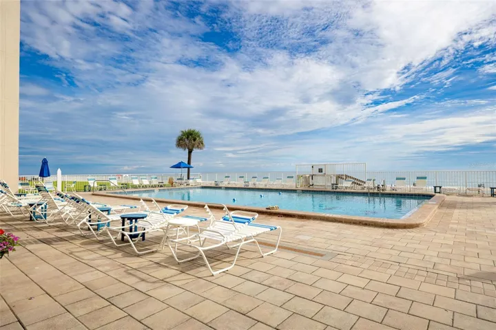 Pool area with lounge chairs and tables