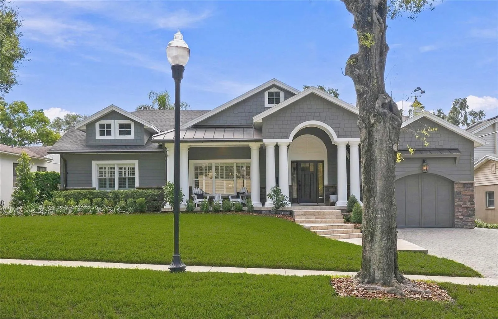 Craftsman-inspired architecture, layered gables & freshly painted rich gray exterior. accented with textured stone & aged copper