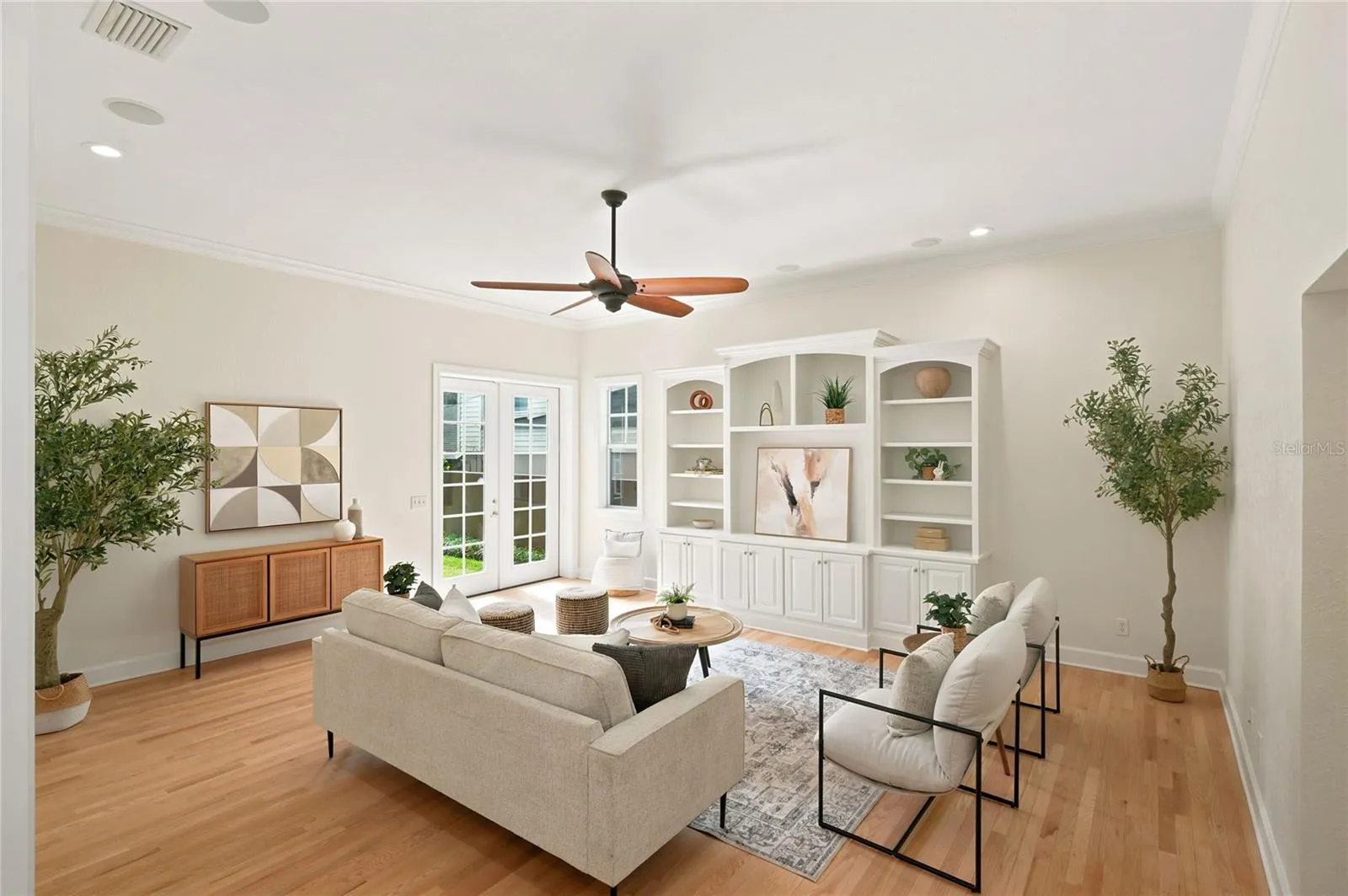 Family room with crown molding, new recessed lighting, architectural statement ceiling fan & custom built-in cabinetry & display shelving