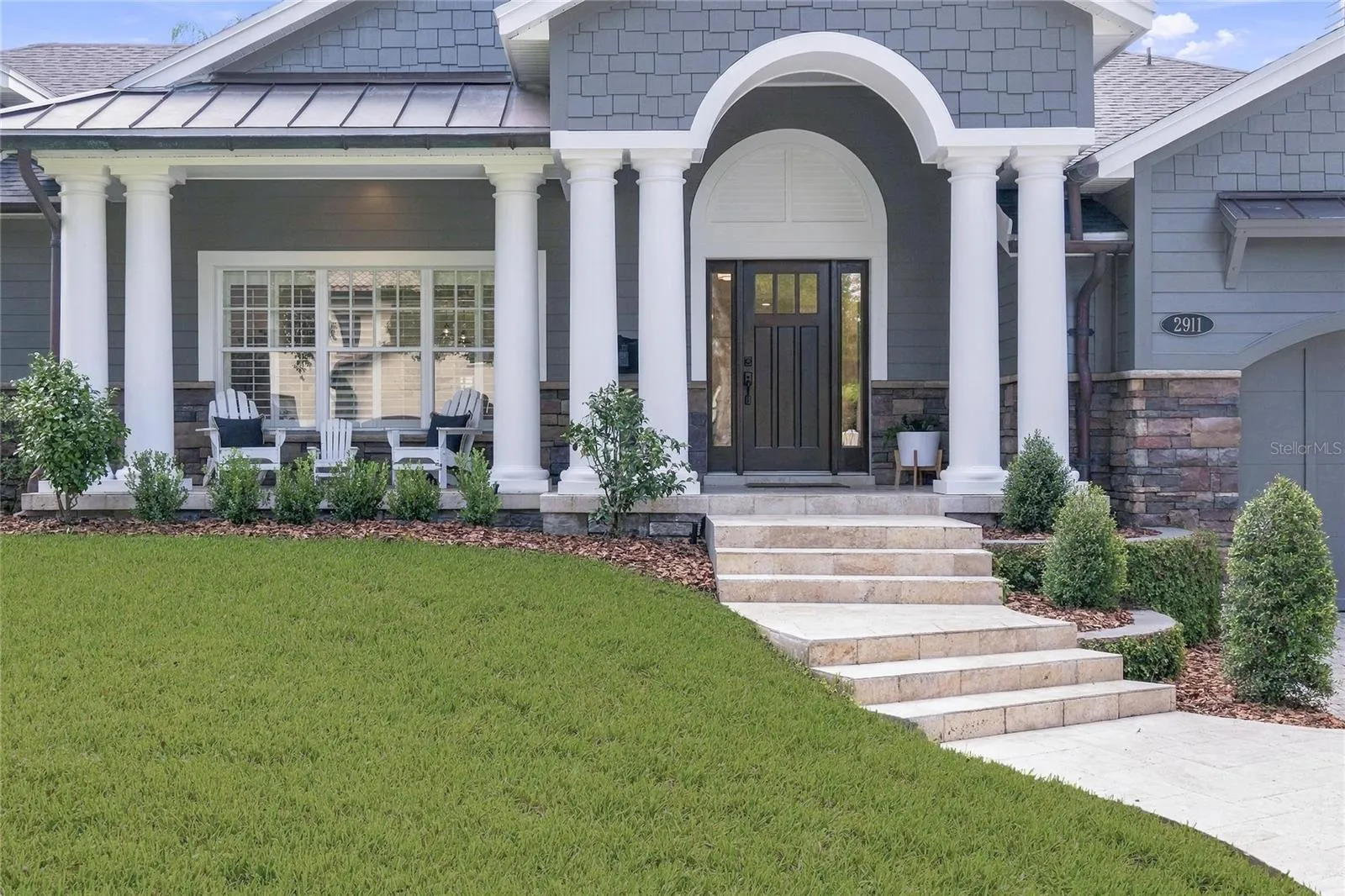 Arched entry & wide travertine front steps create a gracious approach.