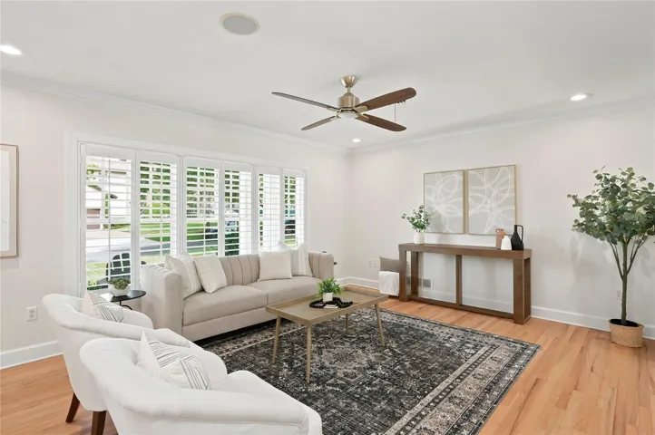 Living space with big front windows & shutters bringing in lots of light