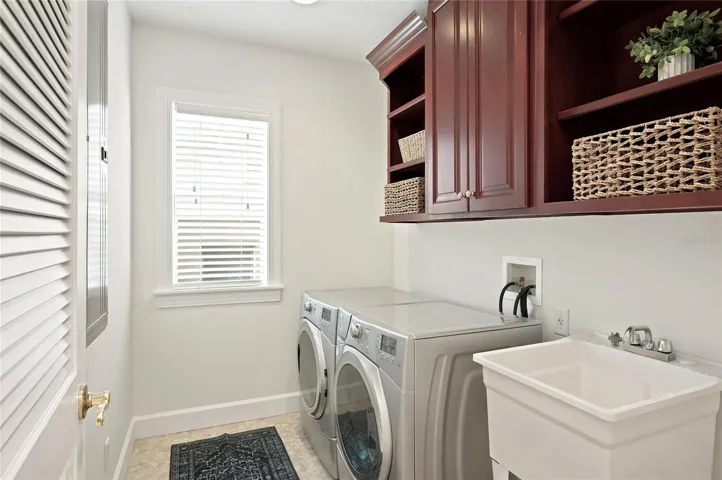 Laundry room with cabinetry, open shelving & utility sink