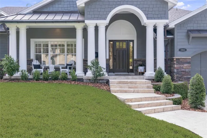 Arched entry & wide travertine front steps create a gracious approach.