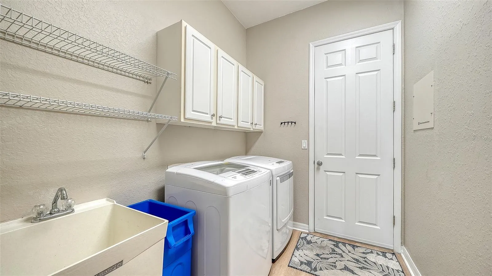 Workable laundry room wtih storage, sink and newer (2024) washer and dryer