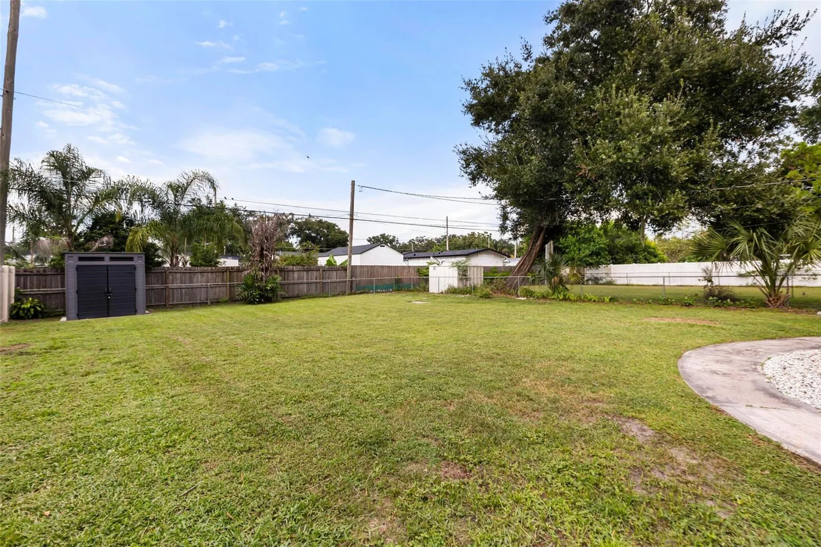 Expansive fenced in backyard with a storage shed