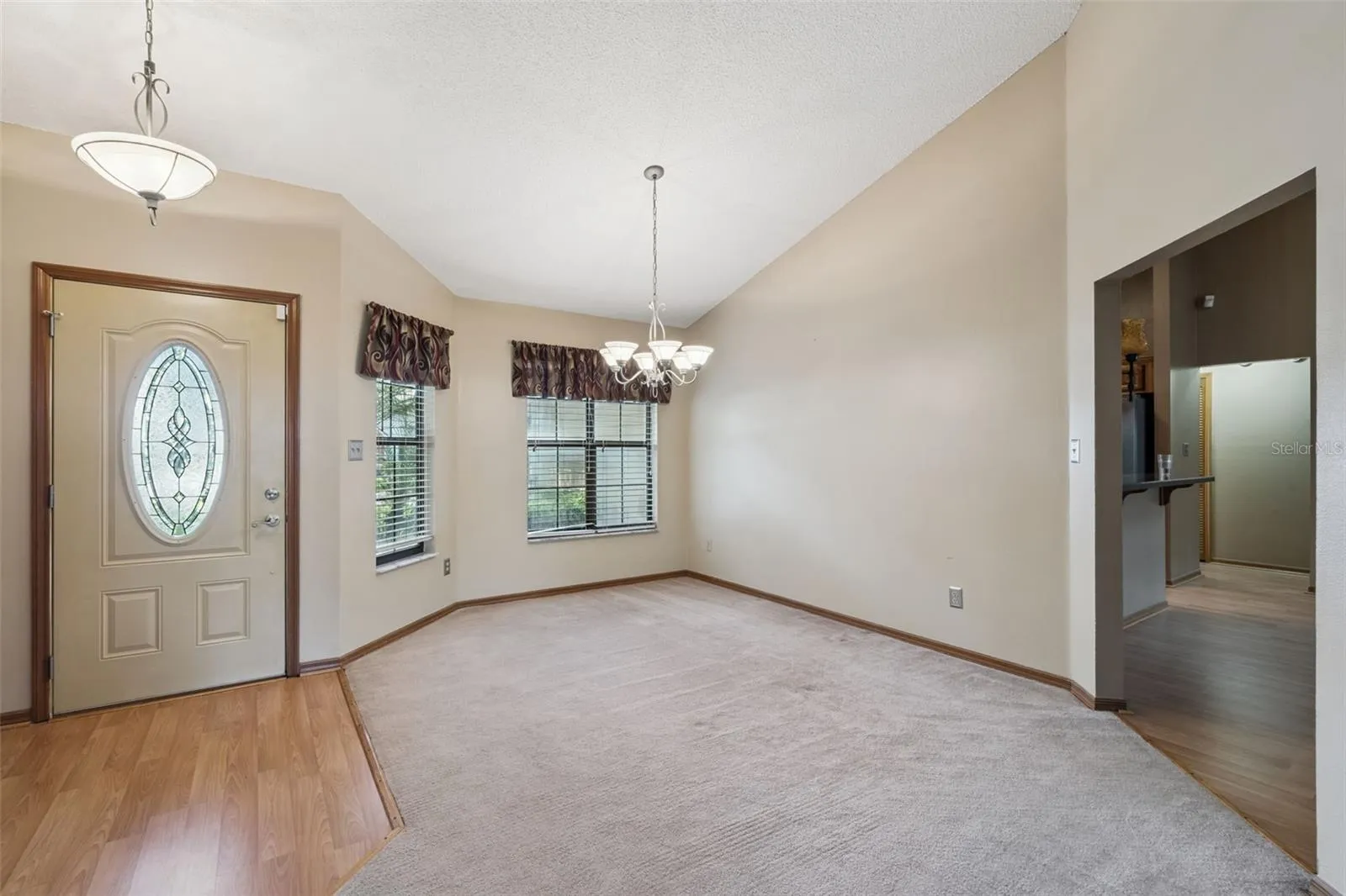 Welcoming foyer opens to a bright, spacious formal dining room with vaulted ceilings.