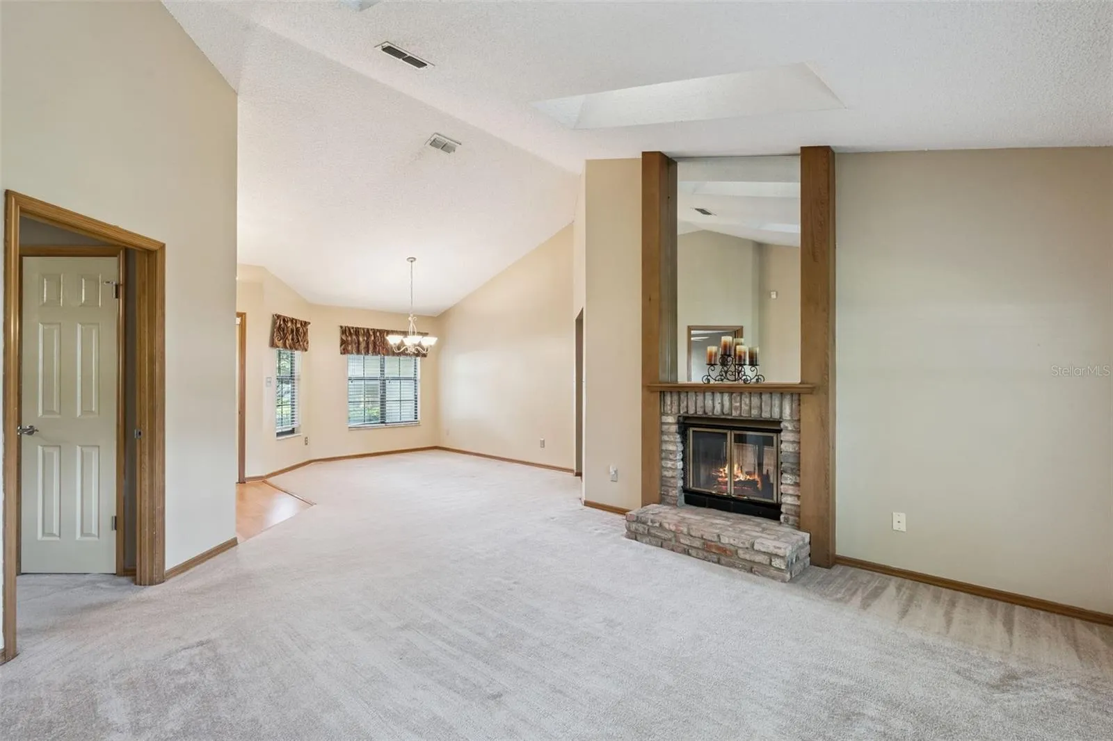 Spacious living and dining areas with soaring vaulted ceilings, skylights and a double-sided brick fireplace.