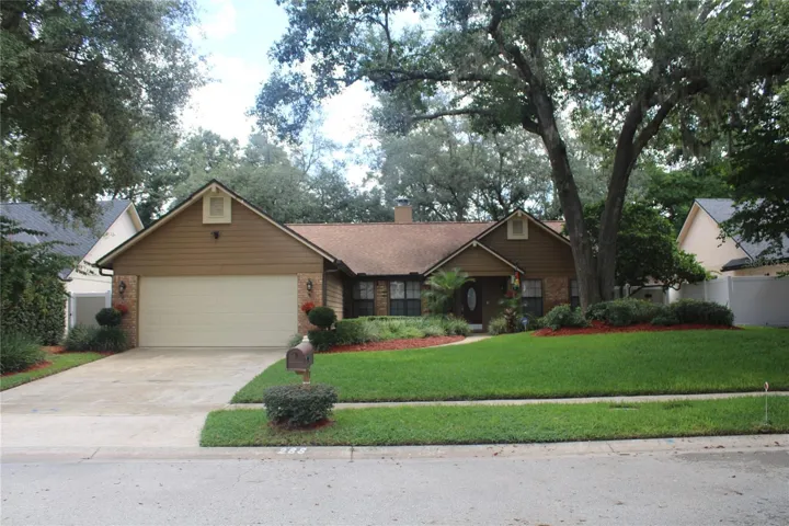 Charming curb appeal framed by mature oaks, lush landscaping and a beautifully maintained lawn.