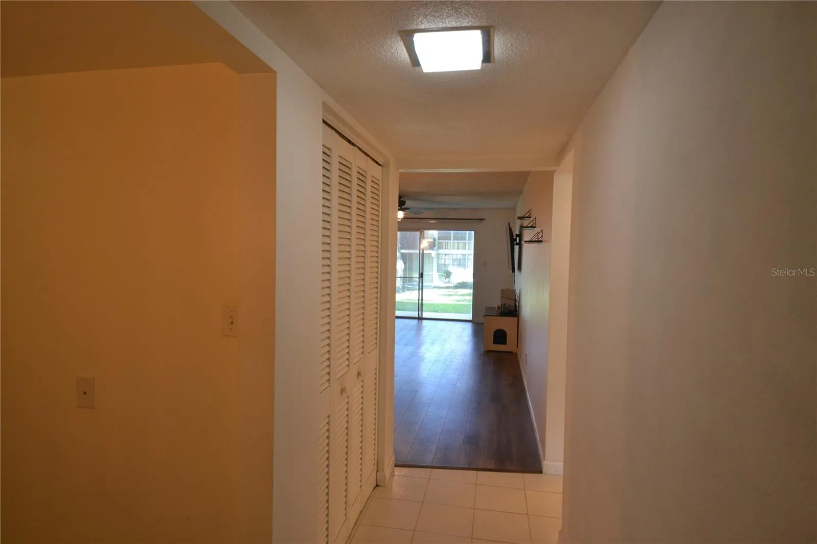 Hallway from the front door.  Large storage closet on the left then looking into the living area