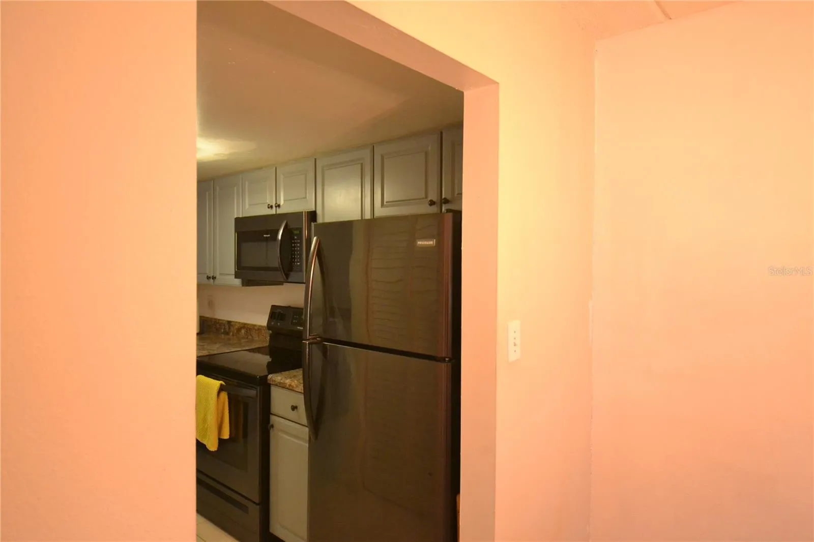 Dining room into the kitchen  Walls are not orange.