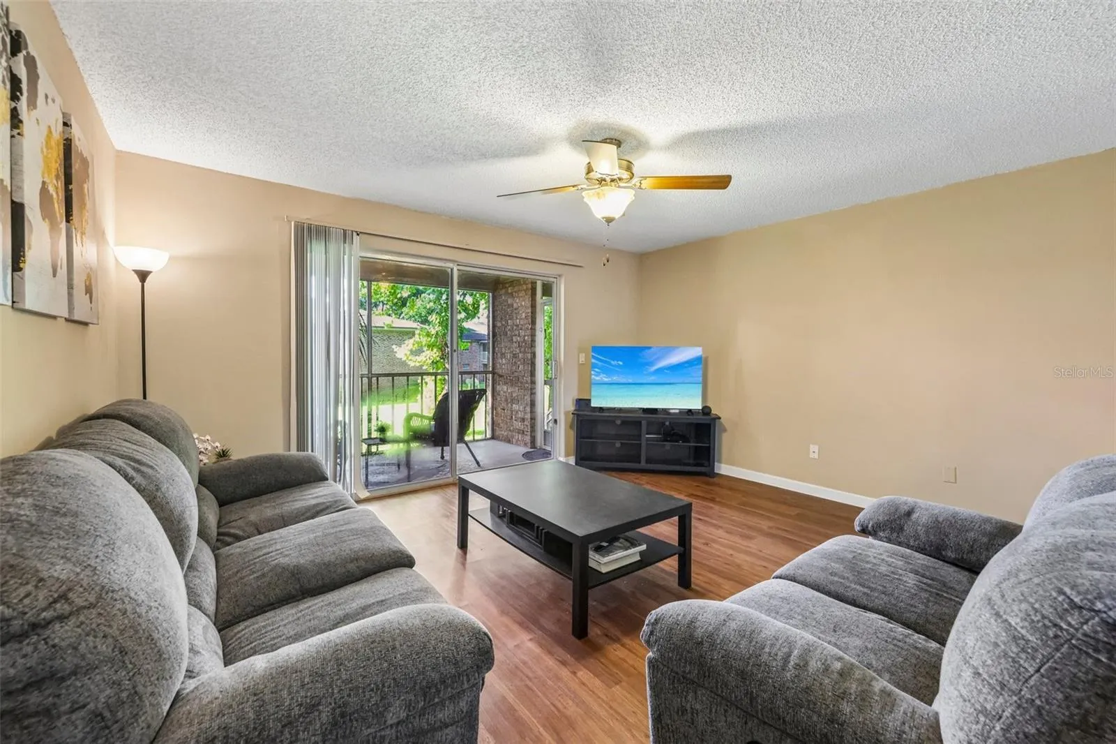 There is a ceiling fan and sliding door to the screened in balcony.