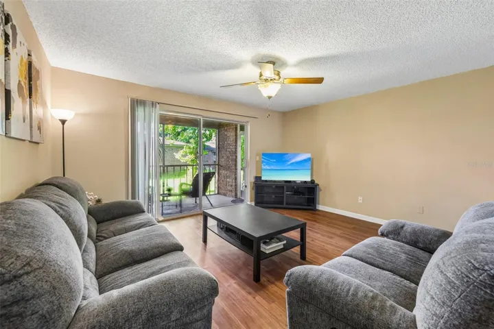 There is a ceiling fan and sliding door to the screened in balcony.