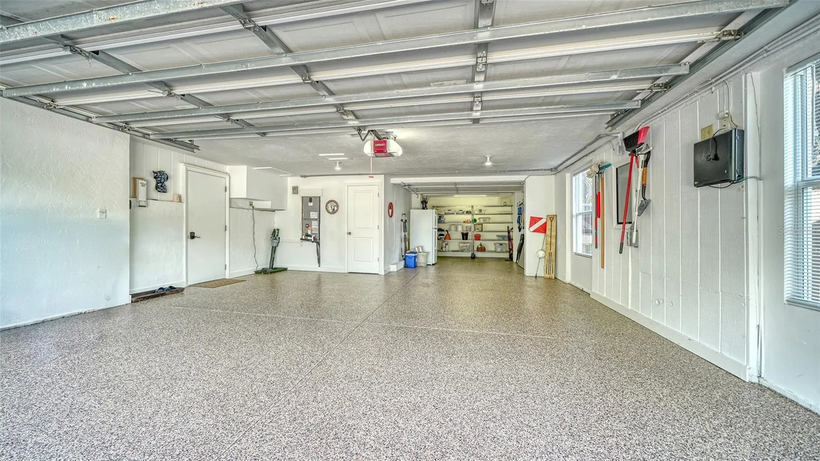 Oversized two-car garage with resurfaced and sealed floor and additional storage.
