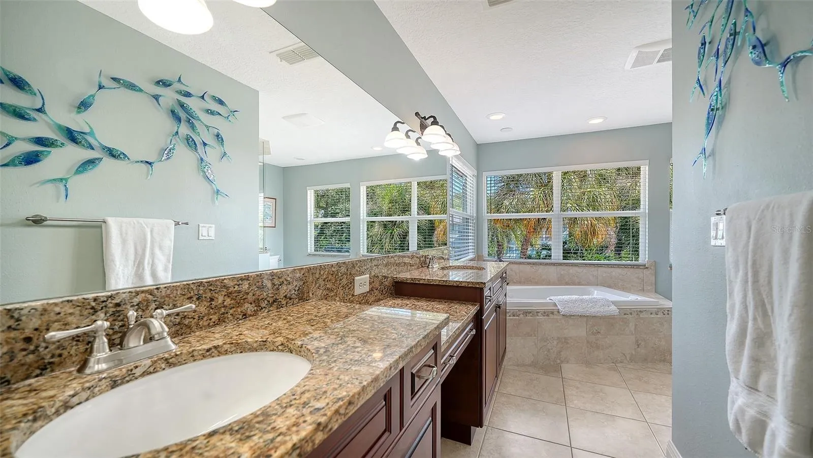 Primary bath with dual vanities, granite countertops and generous storage.
