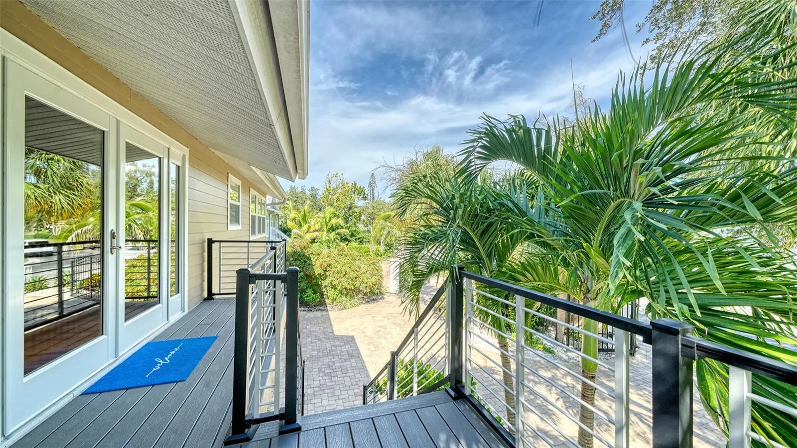 Elevated front entry surrounded by lush tropical foliage.