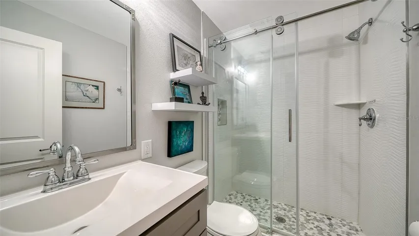 Another view of the guest bedroom showcasing its comfortable proportions.