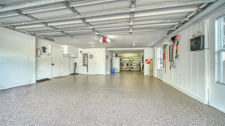 Oversized two-car garage with resurfaced and sealed floor and additional storage.