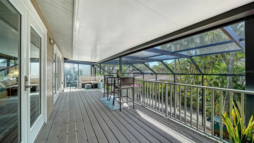 Covered screened balcony overlooking the tropical surroundings.
