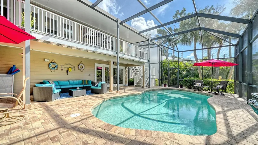 Heated saltwater pool surrounded by a screened enclosure and generous paver deck.