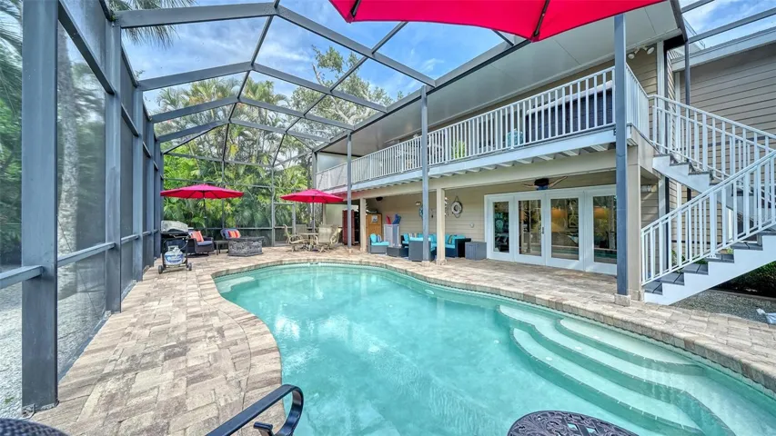 Spacious lower-level living area with French doors opening directly to the pool.