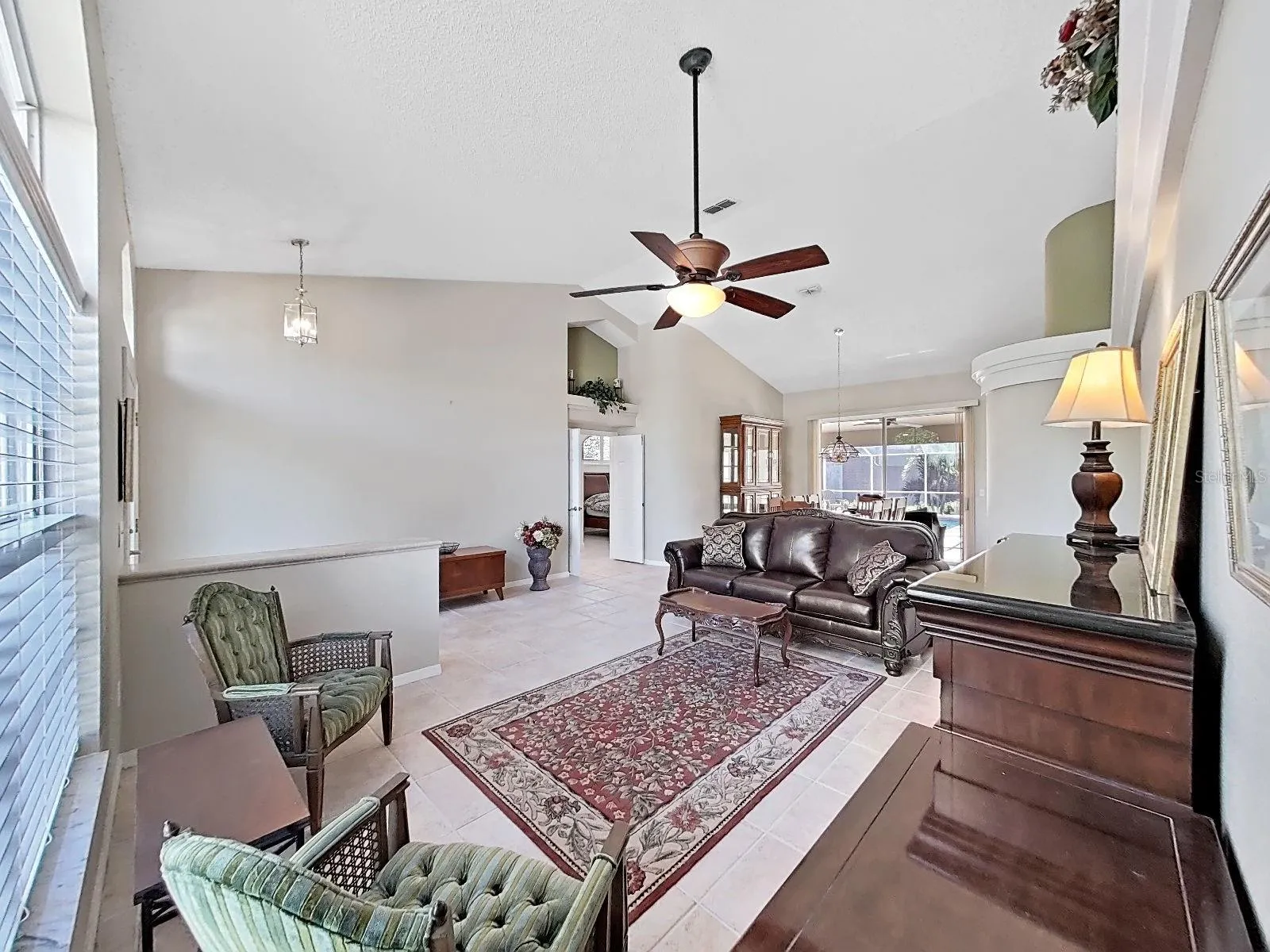 living rm,  note double-door entry to primary bedroom suite, dining room with sliders to pool area and great view of the back yard