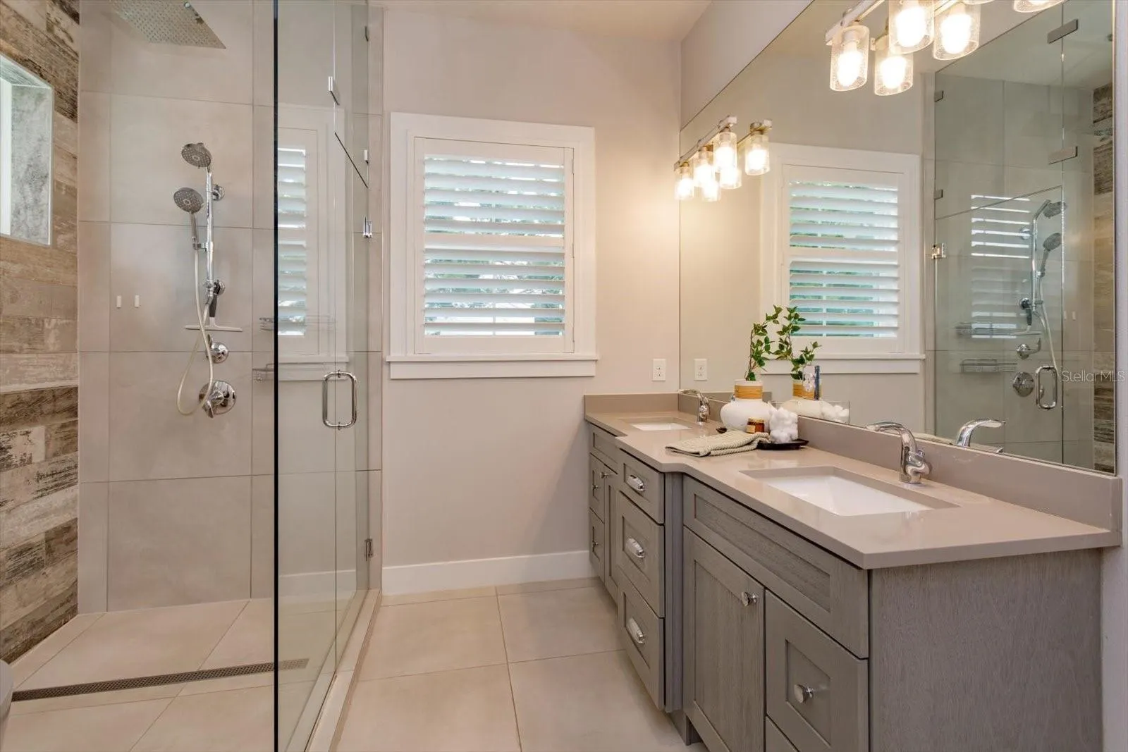 Primary ensuite with dual sinks in a quartz-topped vanity