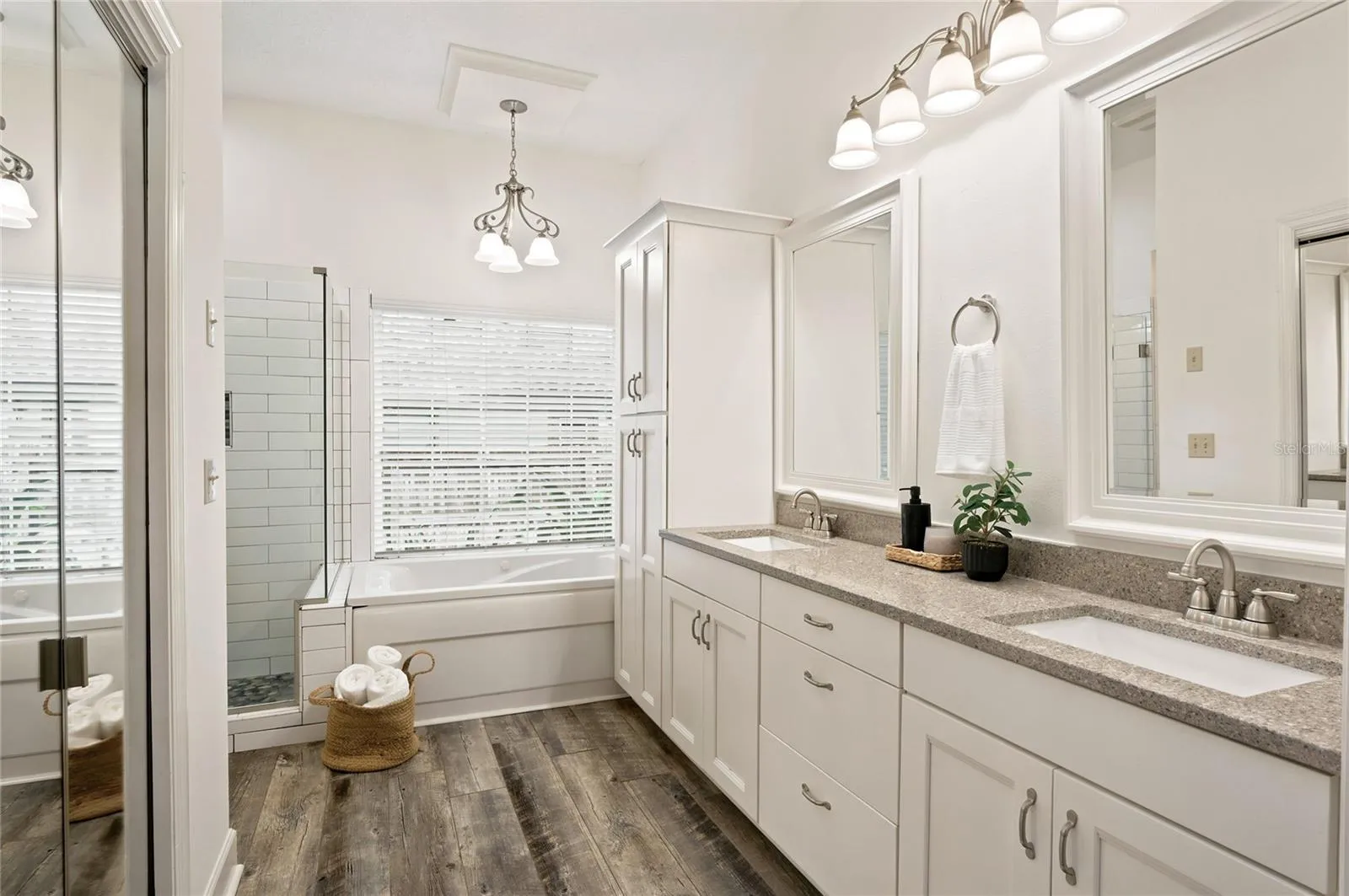 Beautifully appointed en-suite bath featuring a dual-sink vanity, abundant cabinetry and a walk in closet