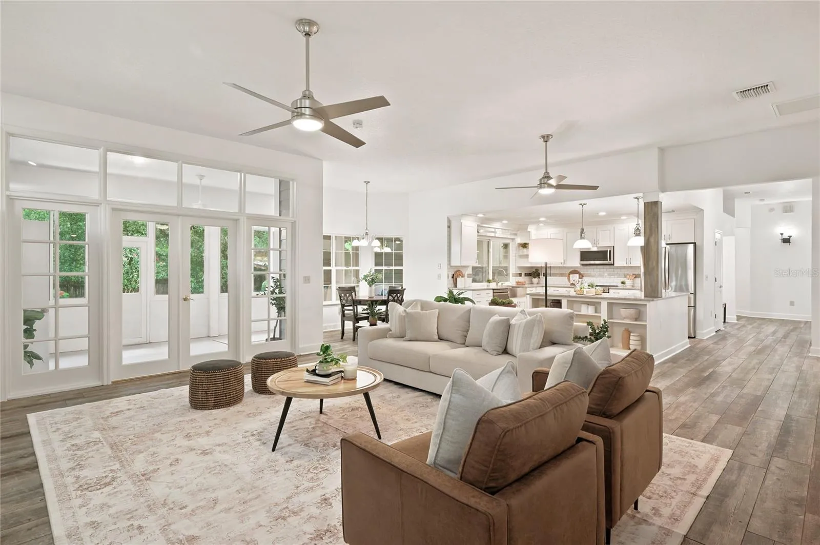 The large family flows seamlessly into the kitchen and casual dining area, with French doors extending the living space outdoors.