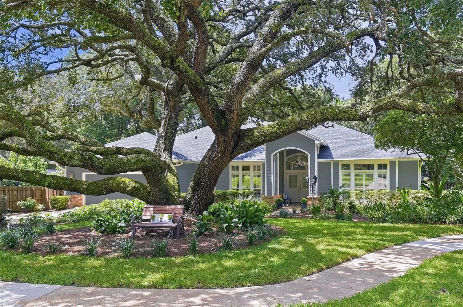 A charming one story residence framed by majestic mature oak trees and lush landscaping, creating a picturesque setting with timeless curb appeal.