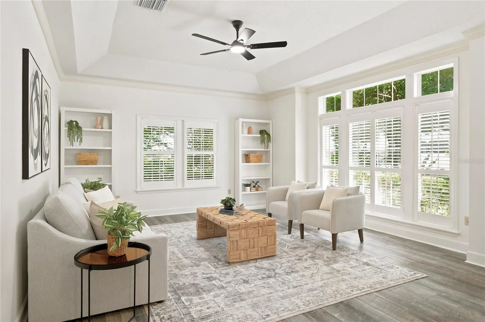A light-filled formal living room features expansive windows overlooking the lush surroundings.