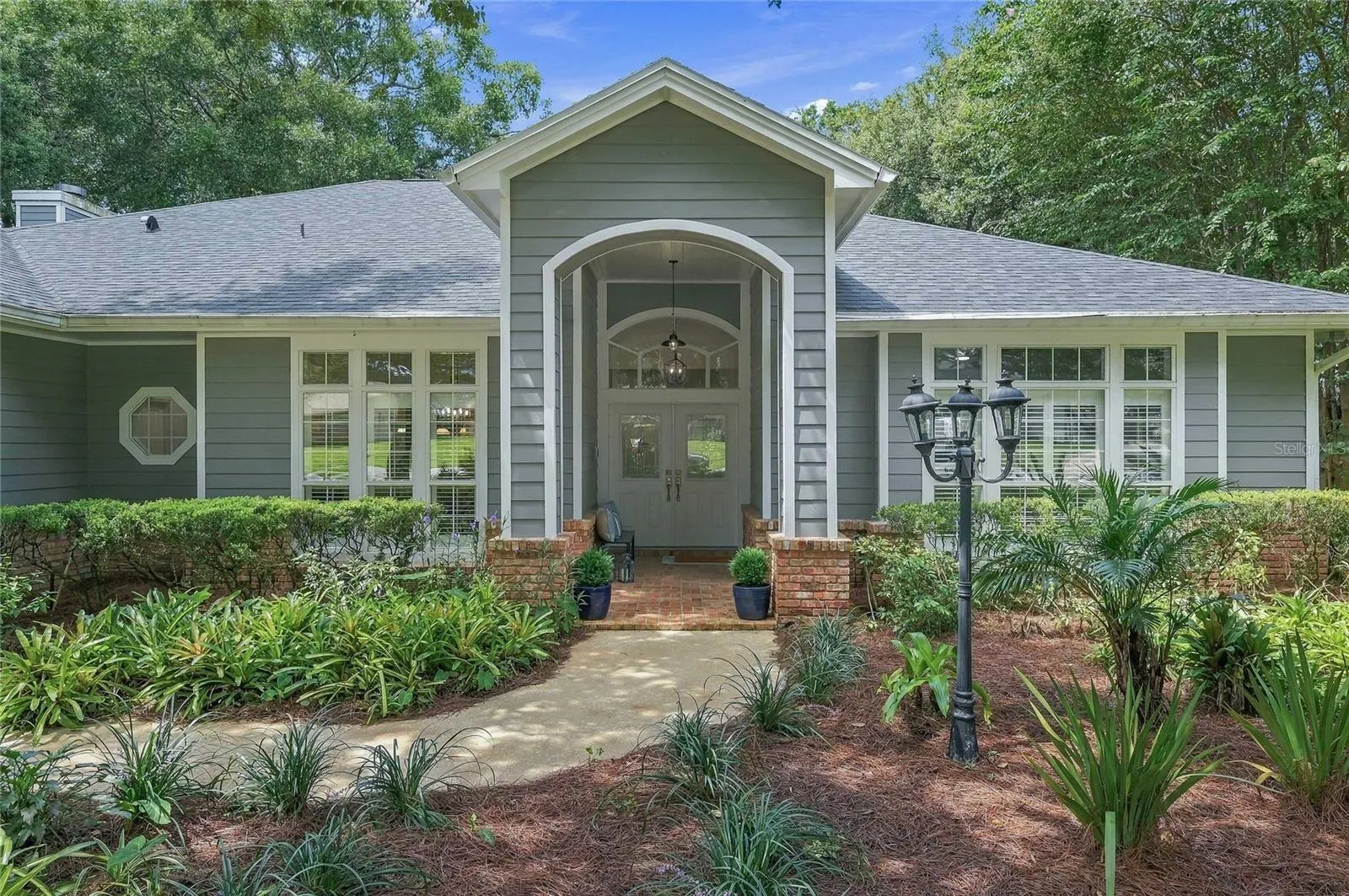A gracious arched entry framed with classic brick accents creating a warm and welcoming first impression.
