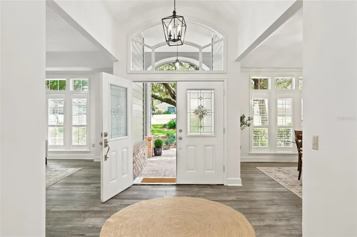 An elegant double-door entry opens to an inviting foyer, where designer lighting and distinctive architectural details set a warm and sophisticated tone for the home.