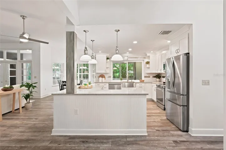 A center island anchors the kitchen, providing abundant workspace with pendant lighting.