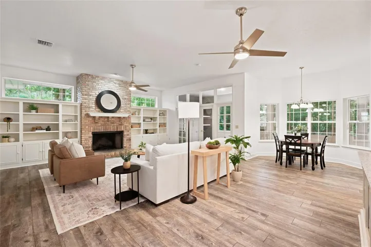 The expansive family room features a classic brick fireplace with custom built-ins and flows effortlessly into the sun-filled breakfast area.