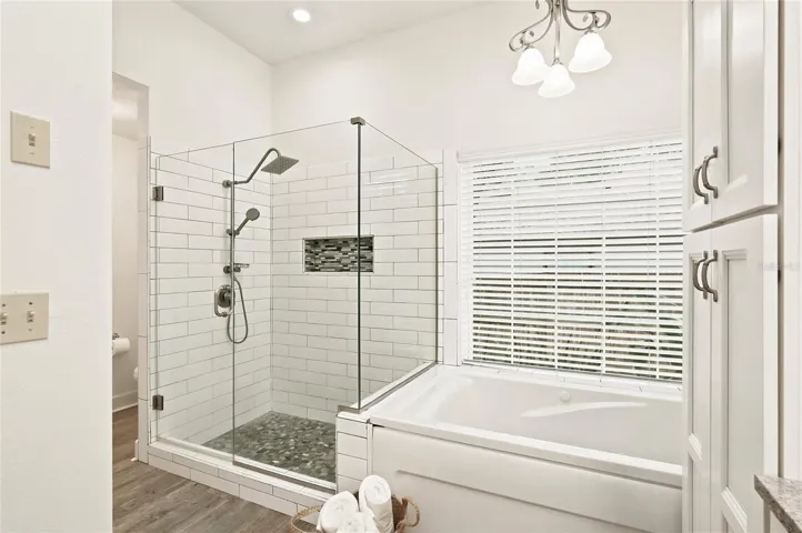 A soaking tub, and a frameless glass walk-in shower with designer tile accents.