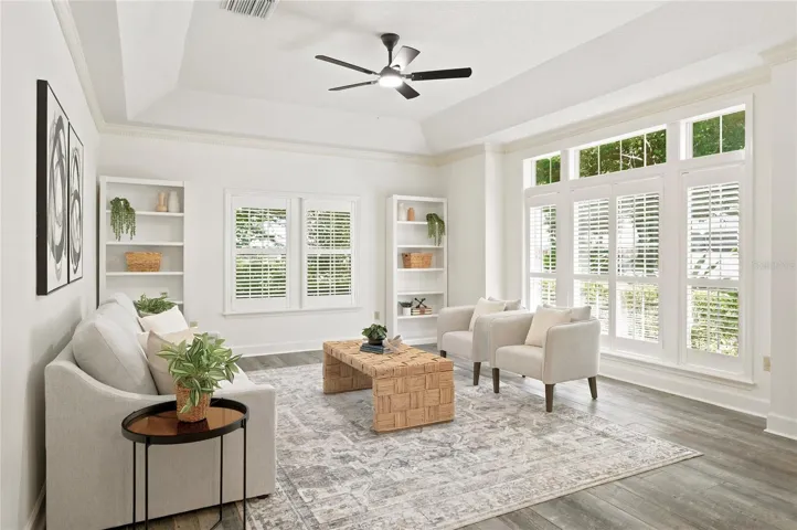 A light-filled formal living room features expansive windows overlooking the lush surroundings.