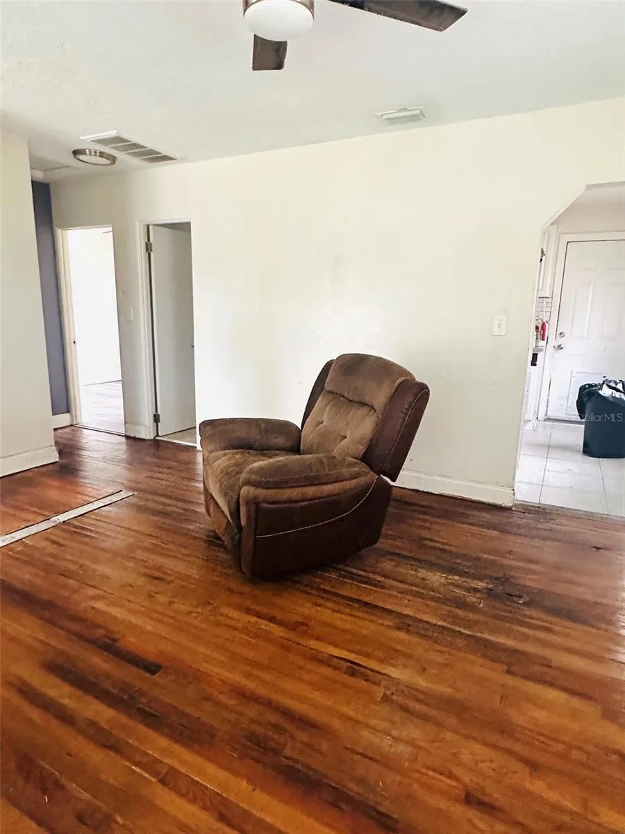 living room with bedrooms on far side and kitchen entrance on the right side.