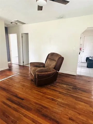living room with bedrooms on far side and kitchen entrance on the right side.