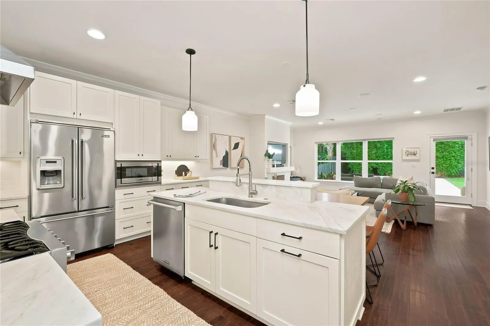 Sophisticated open Kitchen with marble countertops and white cabinetry