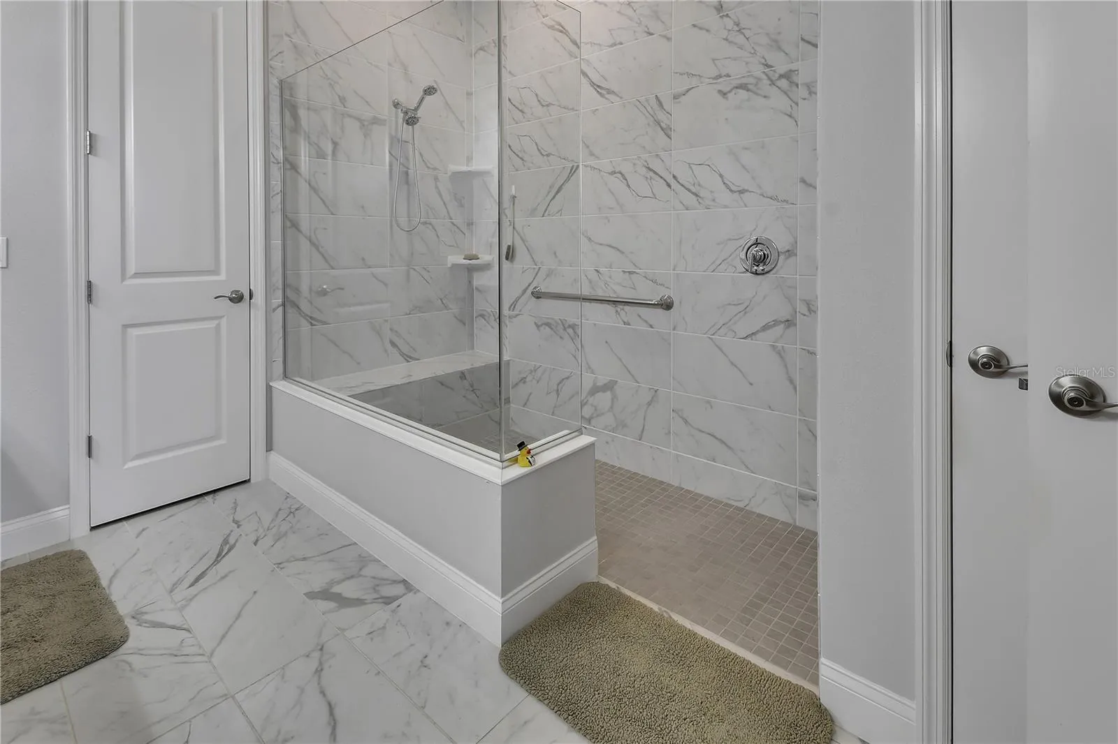 Walk-in shower has bench and grab bar. Privacy Lavatory.